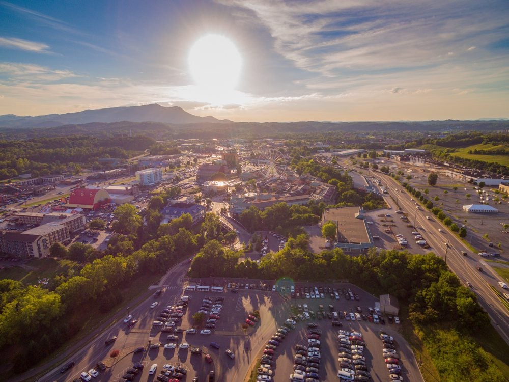 Drone, aerial, high altitude view of setting sun on the main strip in Pigeon Forge, Tennessee