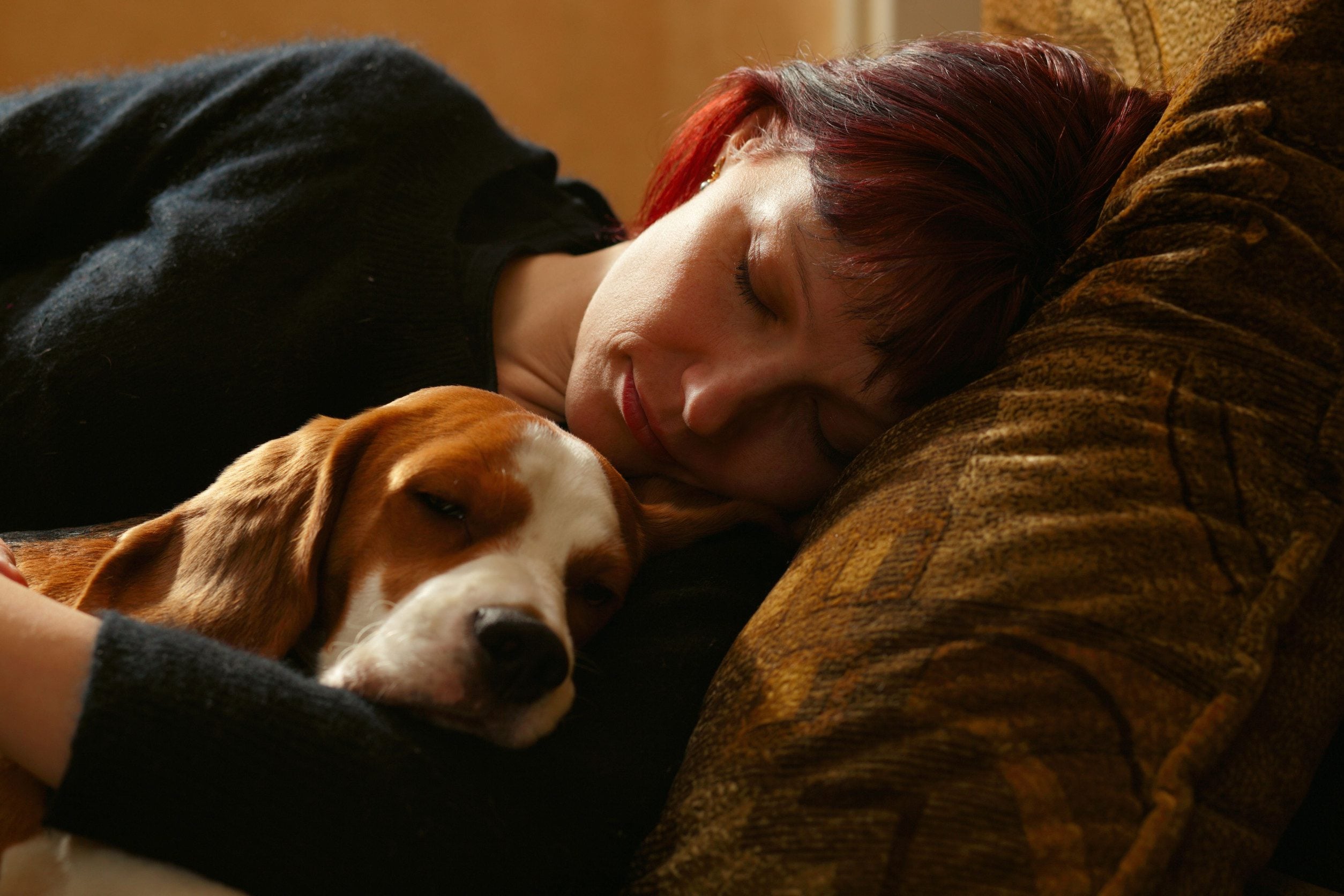 Woman napping with her emotional support animal.