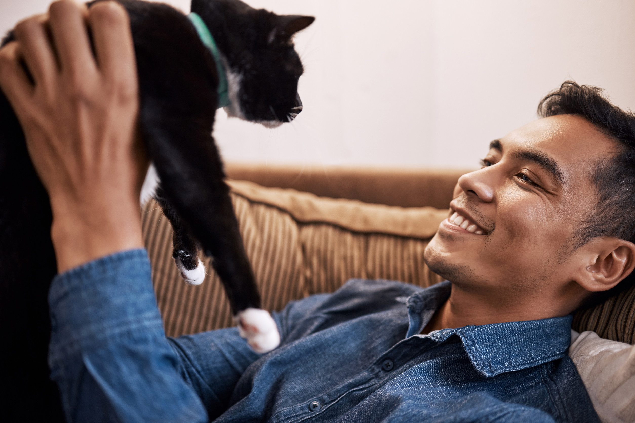 A man smiling warmly as he lifts his emotional support animal in Raleigh, NC.